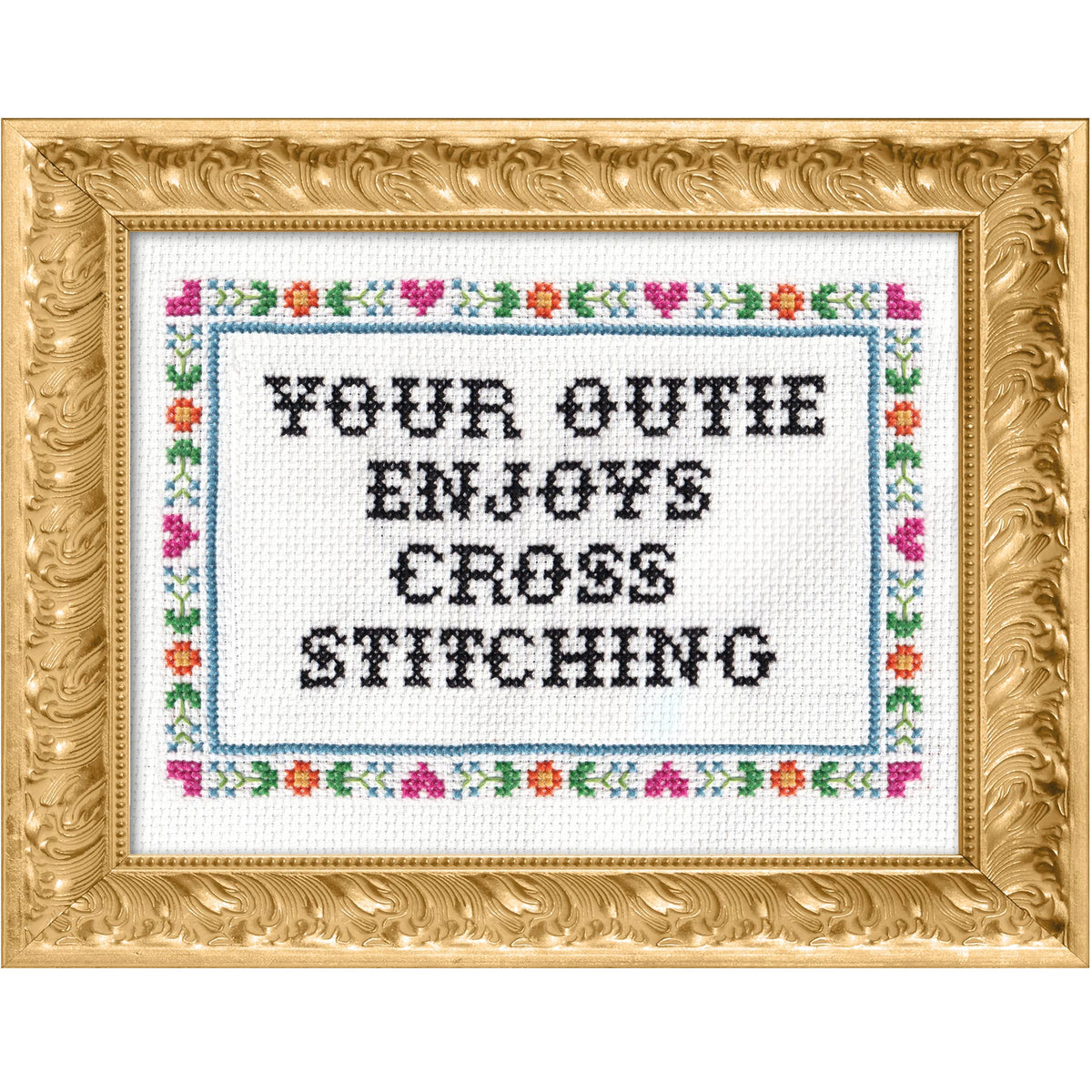 Cross-stitched text that says "your outie enjoys cross stitching" in a decorative gold frame with floral border
