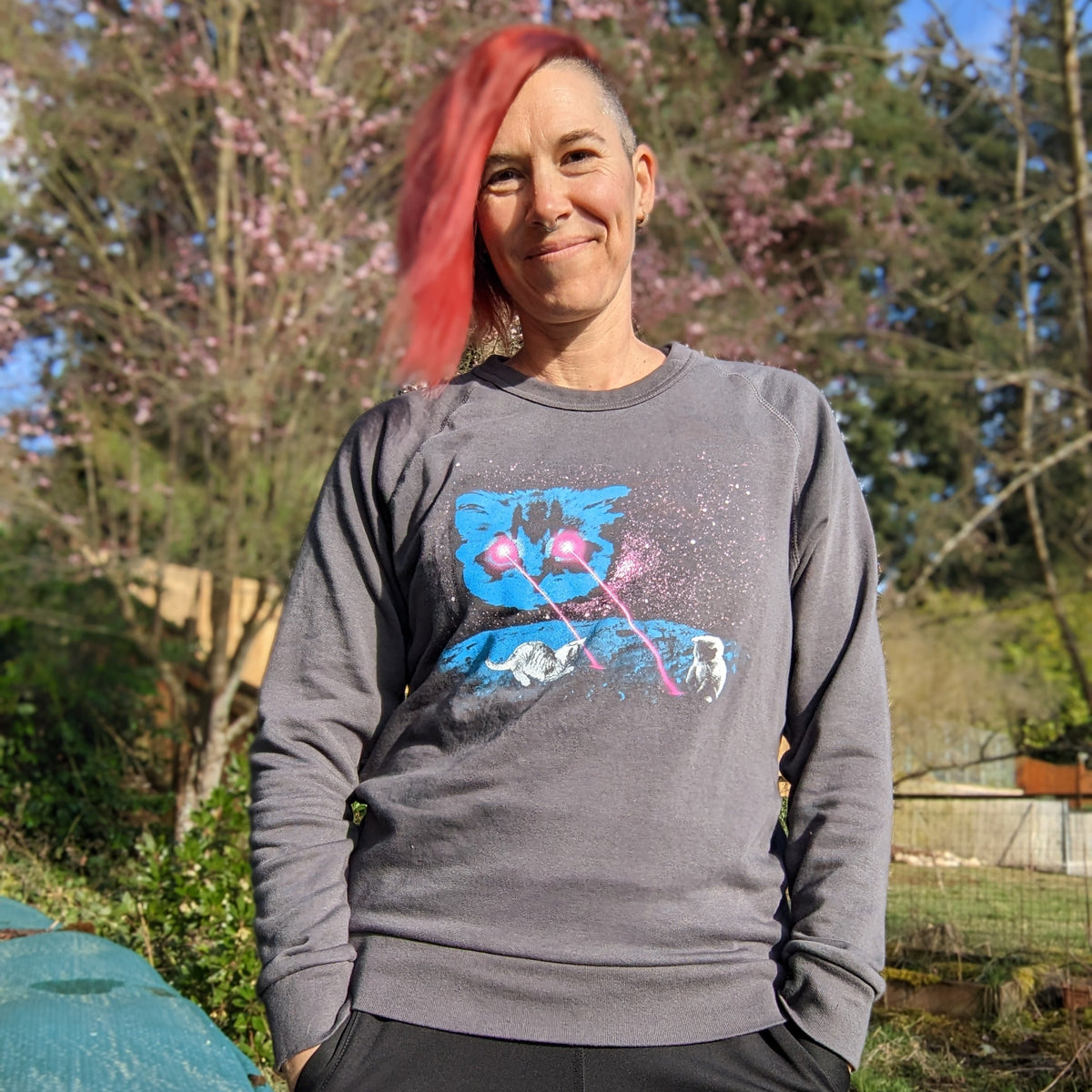 Person wearing a gray sweatshirt with our Meta Laser Cat design outdoors