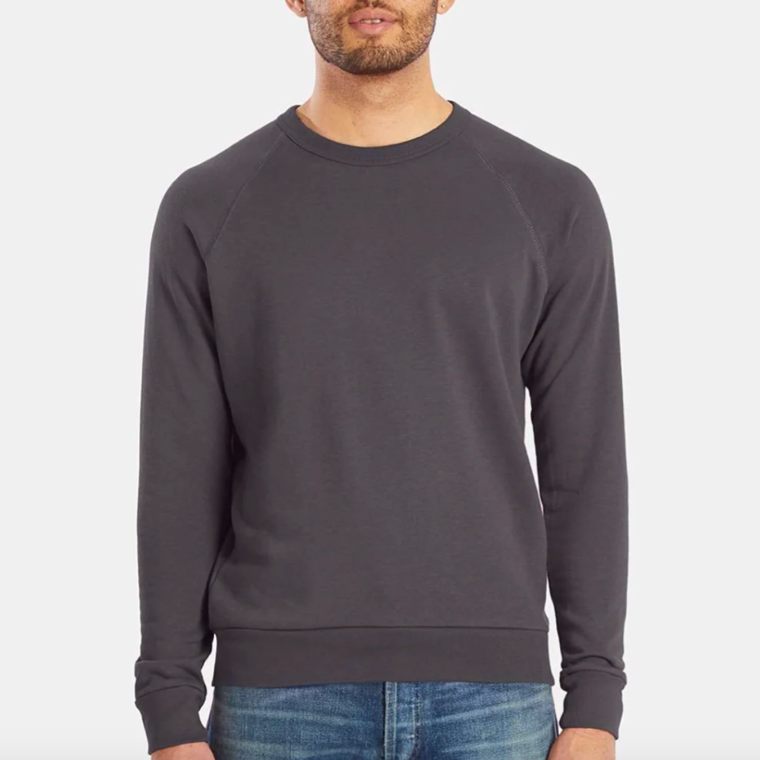 Man wearing a dark gray sweatshirt on a light gray background