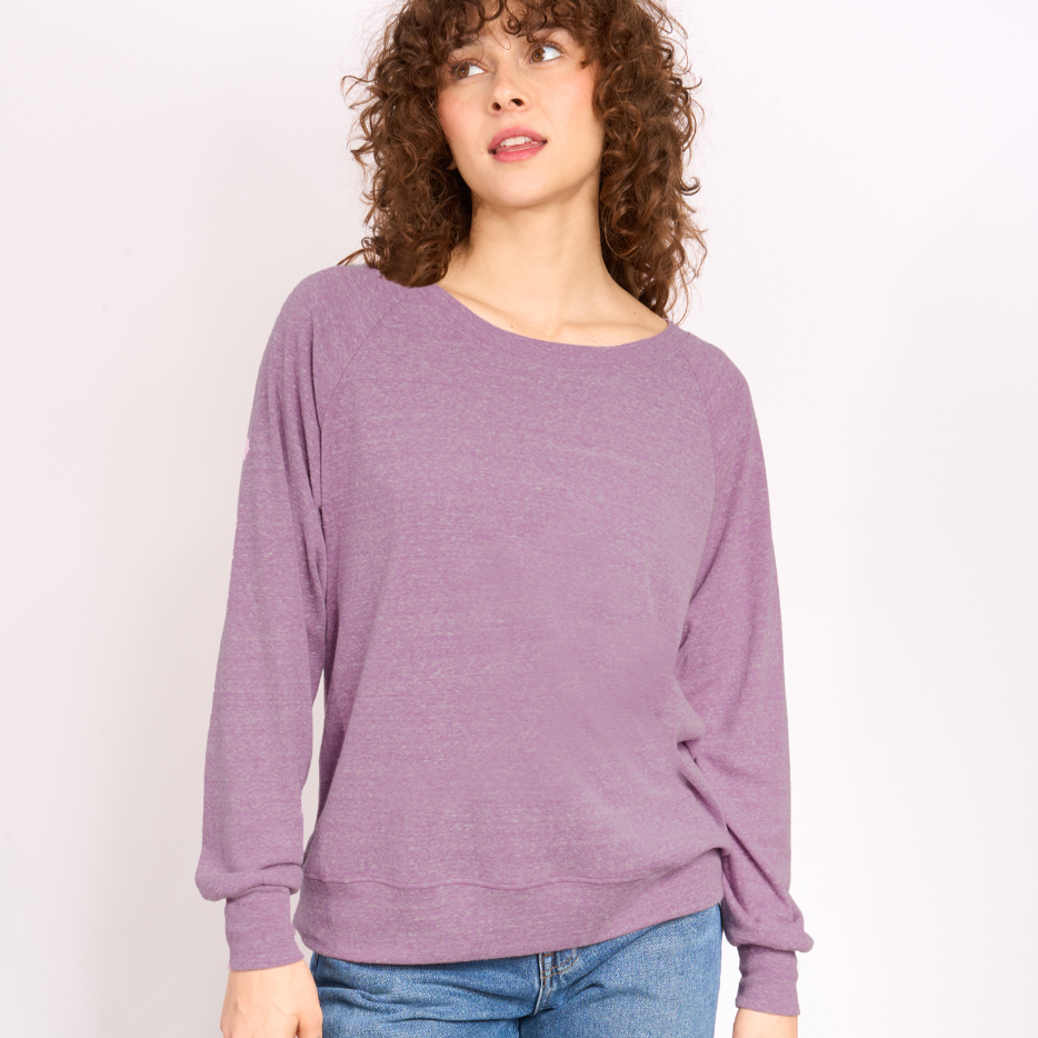 Woman wearing a purple sweater against a plain background.