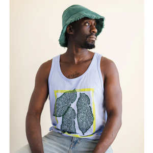 Man wearing a tank top with a leaf design and a green bucket hat, sitting against a plain background.