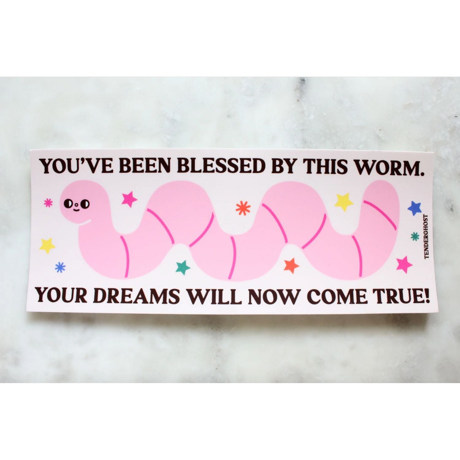 Pink cartoon worm bumper sticker with text that says "you've been blessed by this worm. your dreams will now come true!" on a marble background