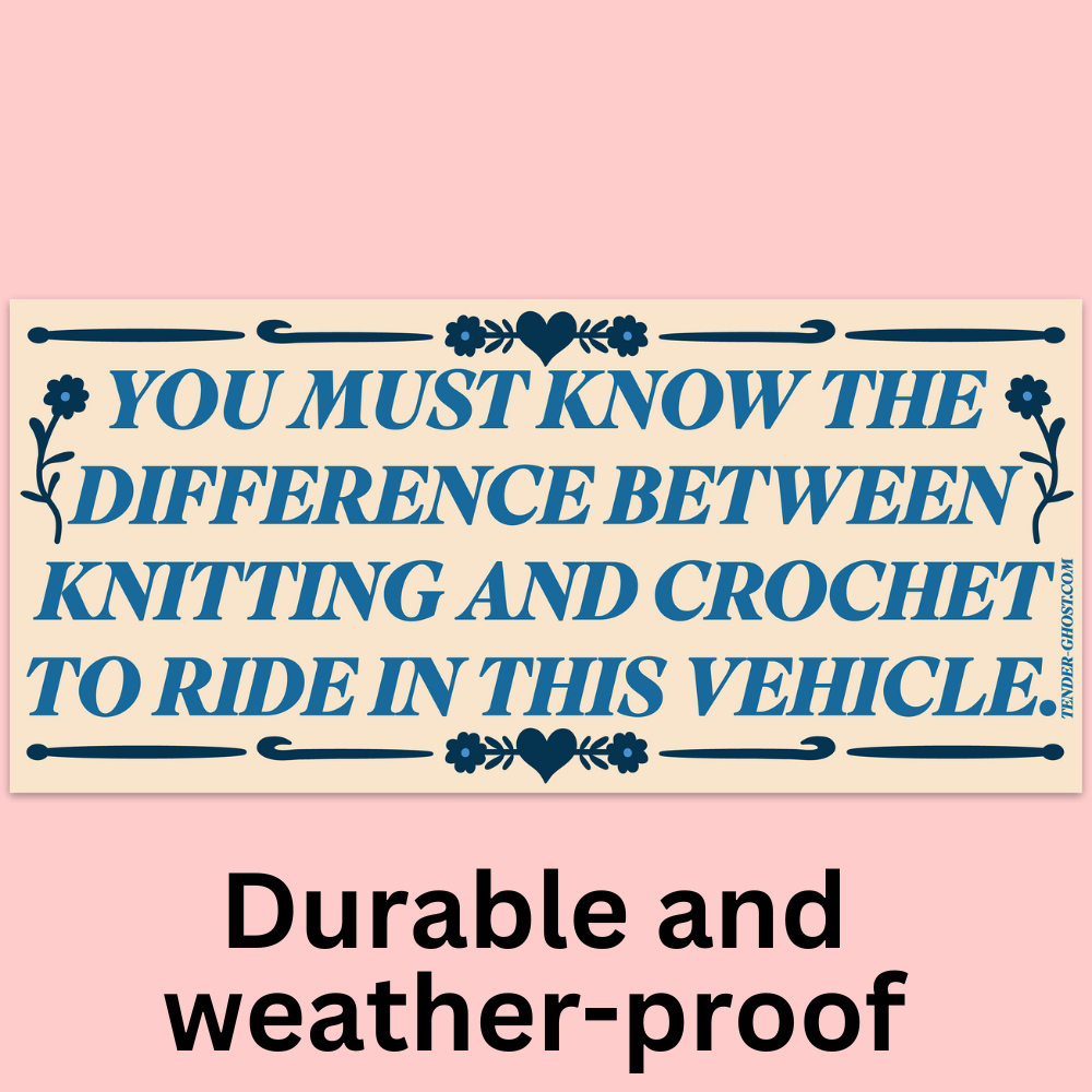 A cream-colored bumper sticker with blue text that reads "You must know the difference between knitting and crochet to enter this vehicle." and a floral border