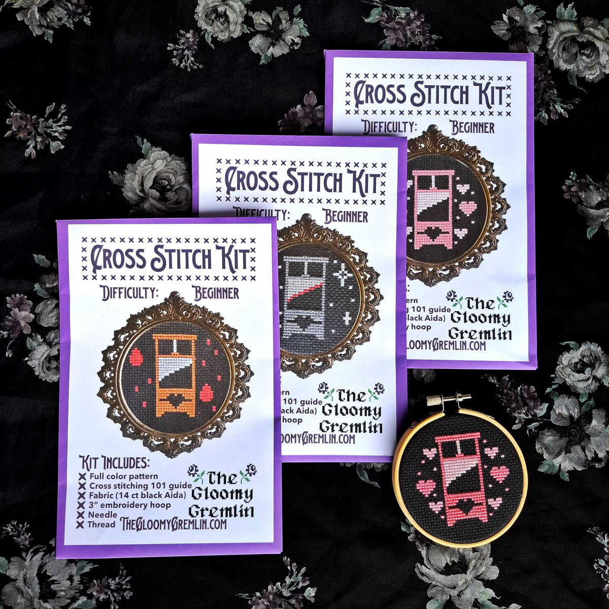 Cross stitch kit with a completed design on a dark floral background
