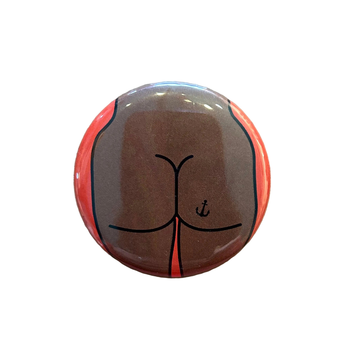 Round button with a design of a butt with an anchor tattoo against an orange background. 