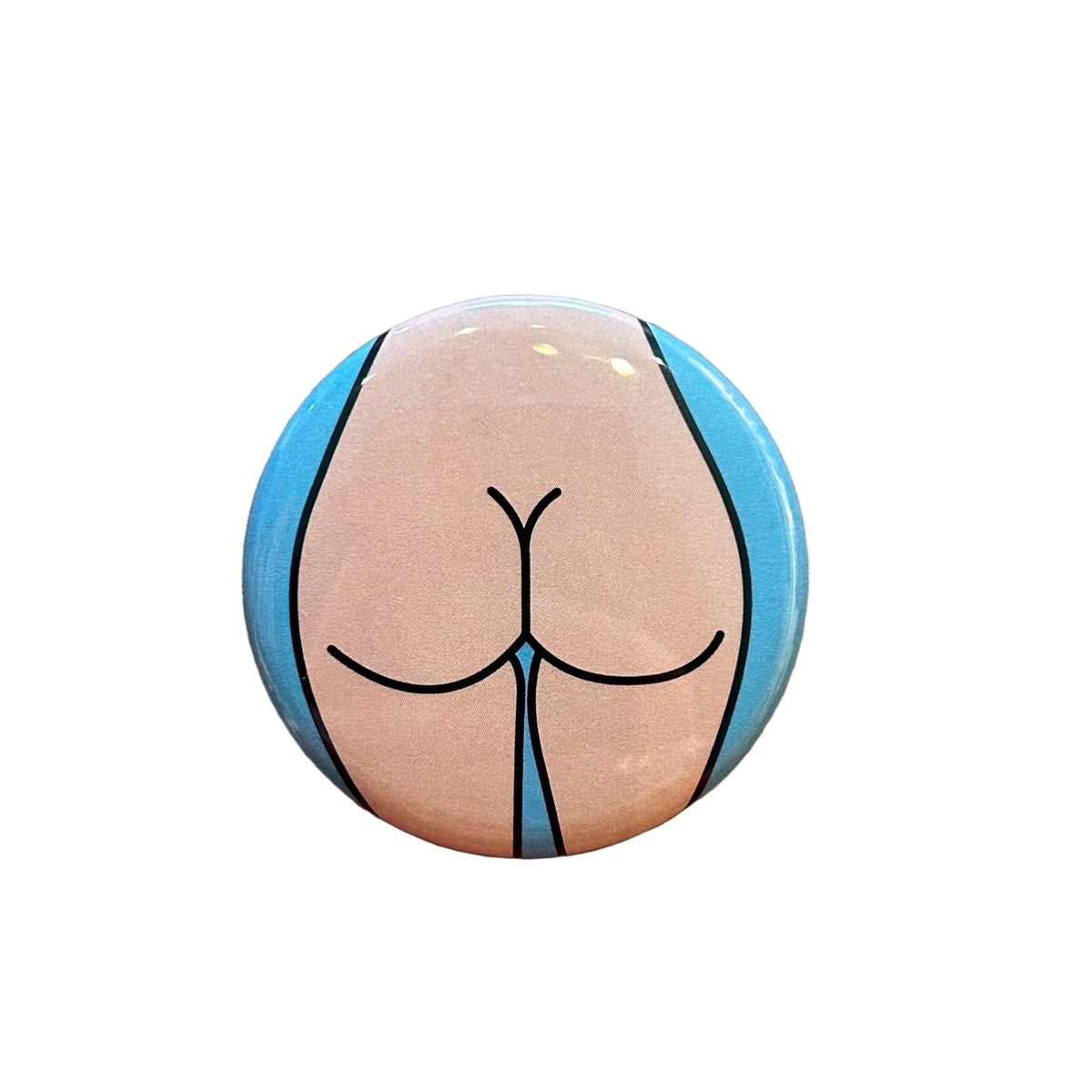 Round button with a stylized depiction of a butt on a wooden surface
