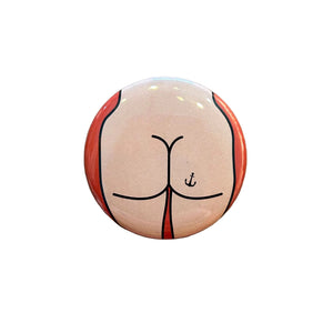 Round button badge with a design on a wooden surface