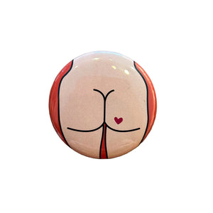 Round button with a design of a stylized butt on a textured surface