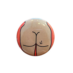 Round button badge with a butt design on an orange background