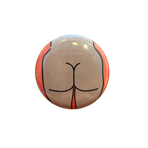 Round button with a butt design on a wooden surface