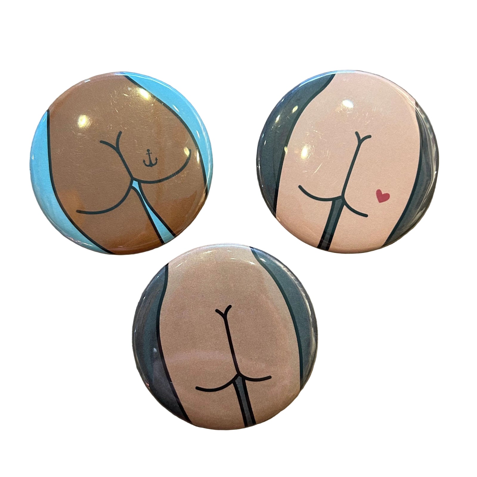 Three round buttons with butts on them on a wooden surface