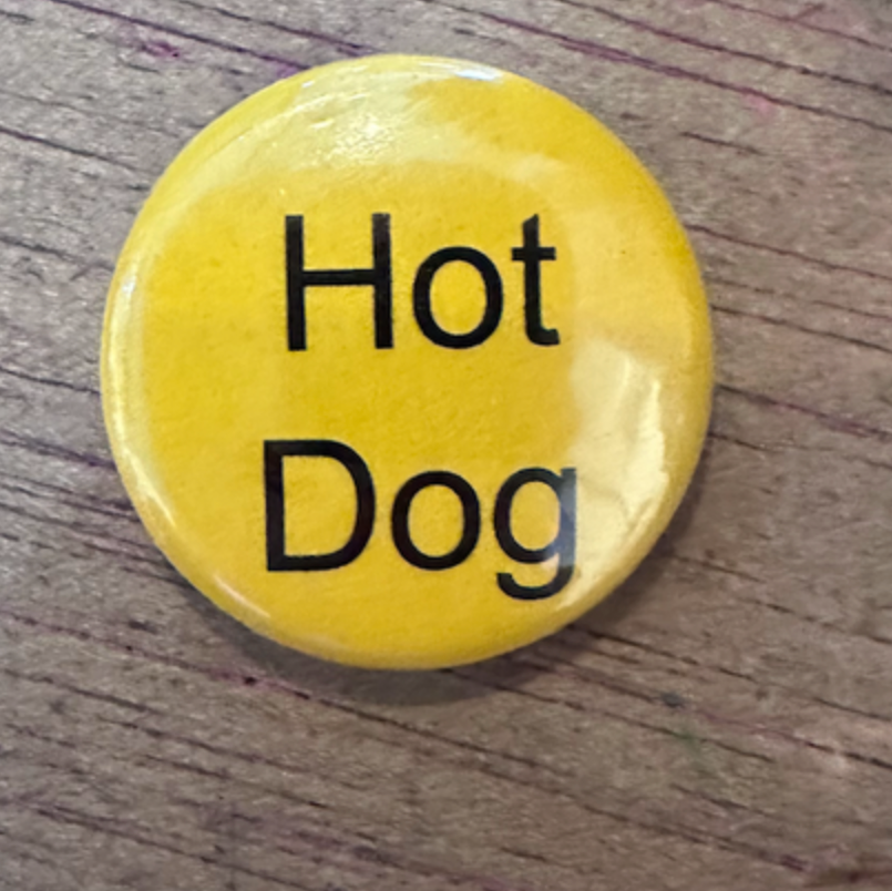 Yellow button with 'Hot Dog' text on a wooden surface
