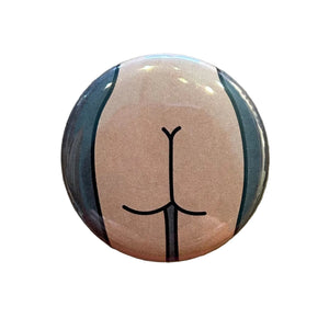 Round button with a simplistic butt drawing on a textured surface