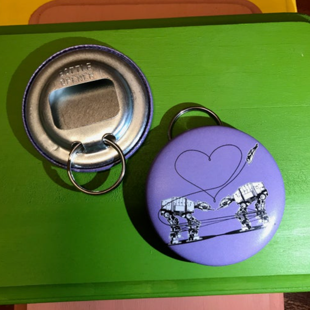 Purple bottle opener with robot design  on a green surface