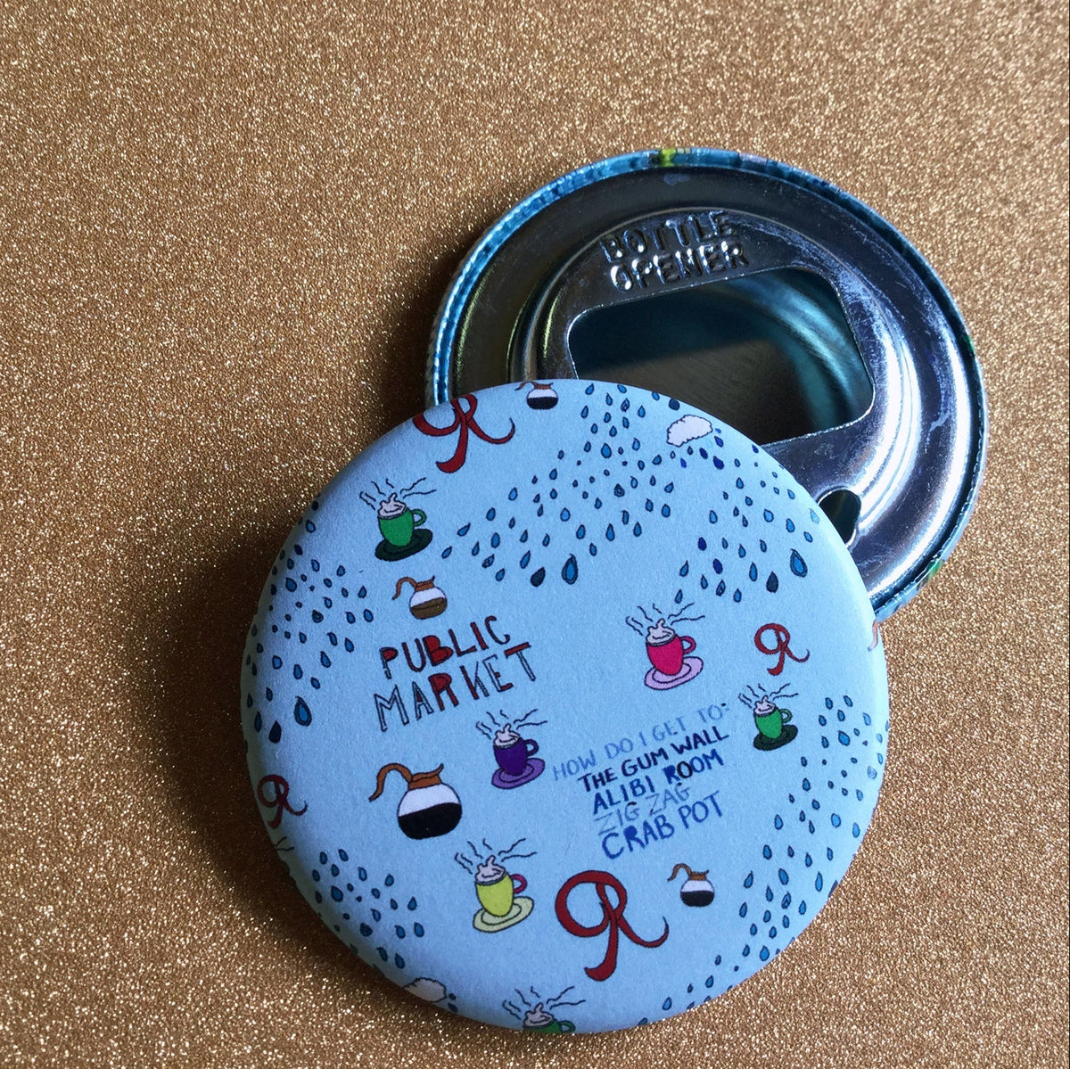 Round bottle opener with colorful design on a glittery gold background