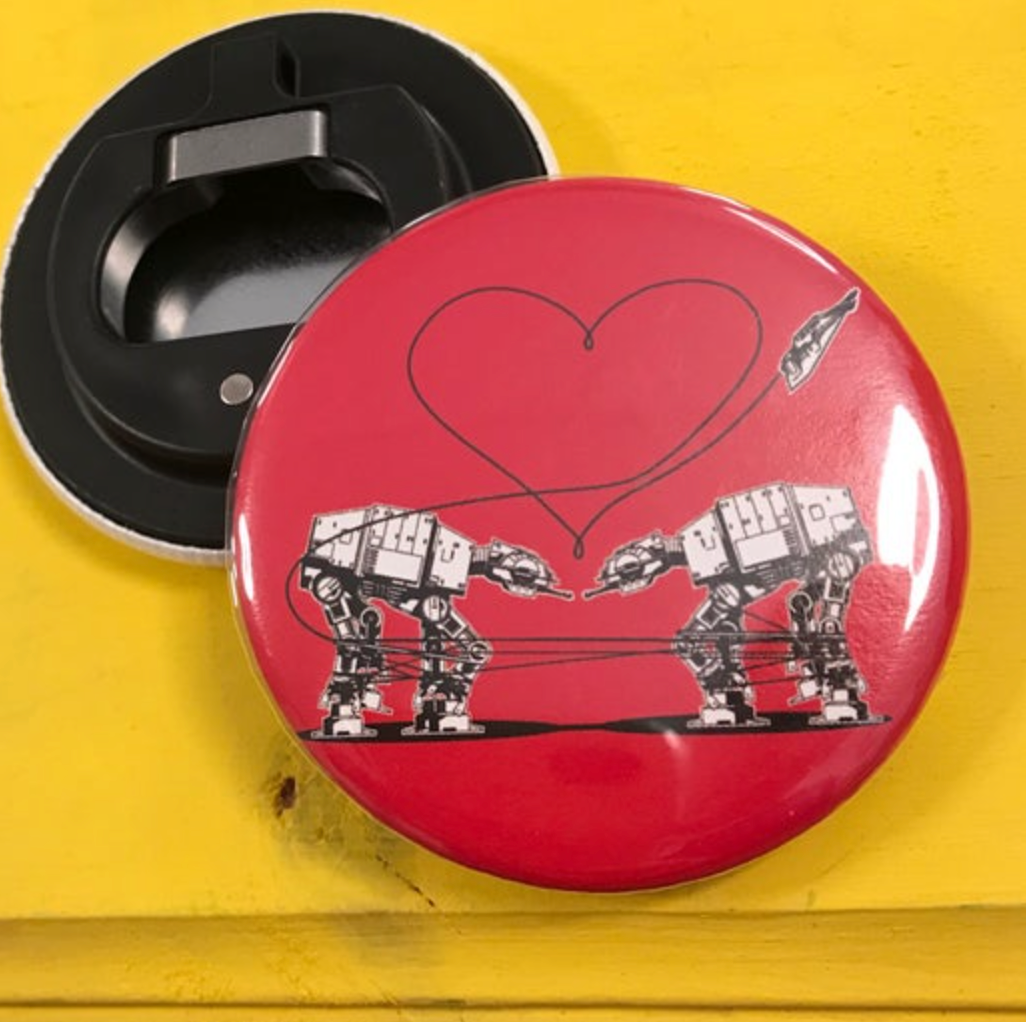 Round red bottle opener magnet featuring the Love AT-AT First Sight design on top of a yellow surface. 
