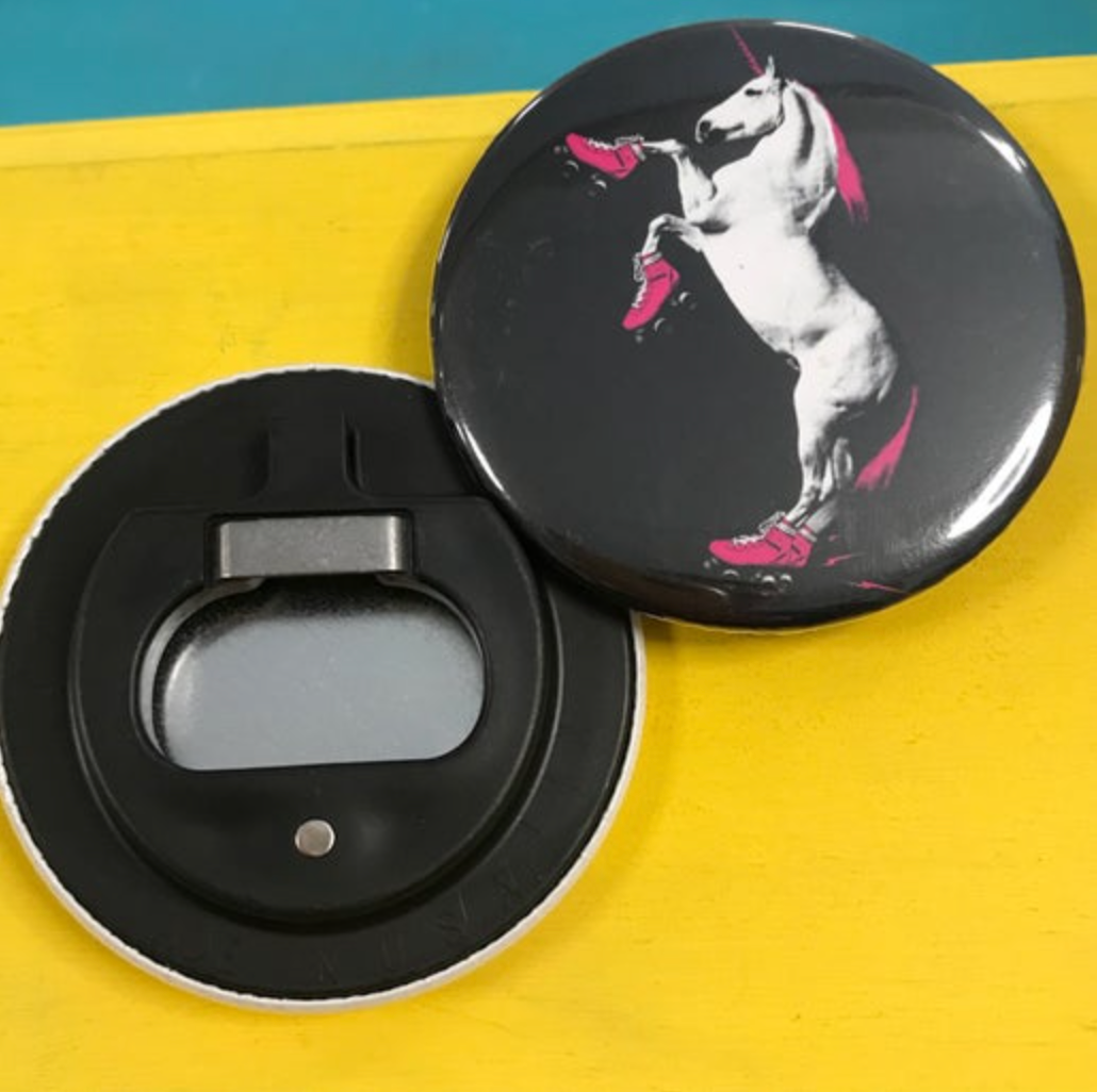 Round bottle opener magnet featuring a unicorn wearing rollerskates against a black background. 