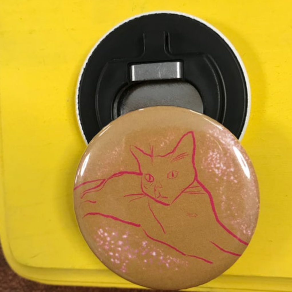 Bottle opener with pink cat design on a yellow background