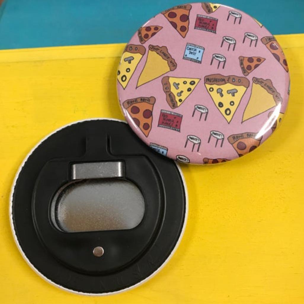 Round bottle opener magnet with pizza slice design against a bright yellow background. 