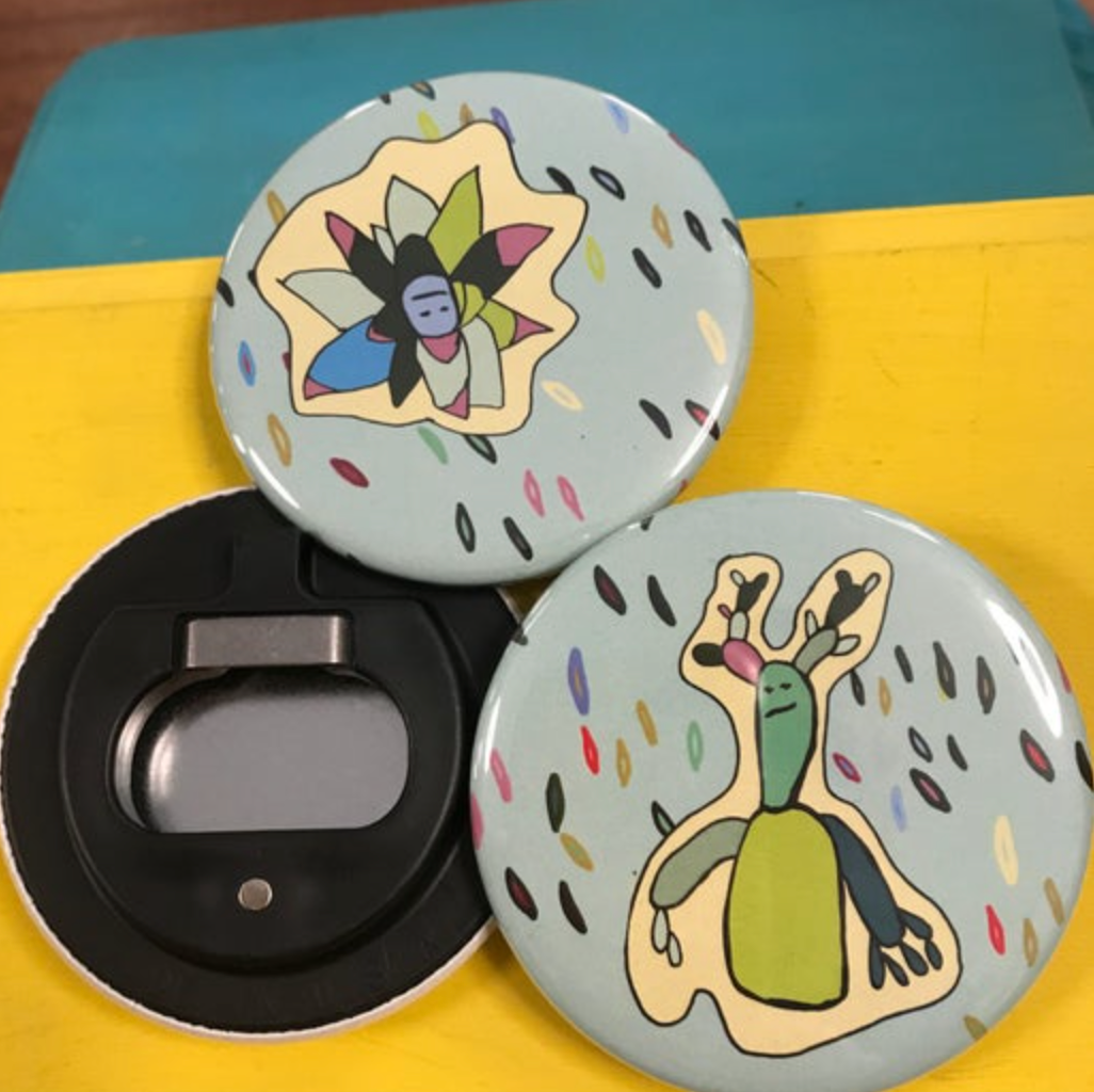 Three round bottle opener magnets; two facing forward with succulent designs on them, and one showing the back. 