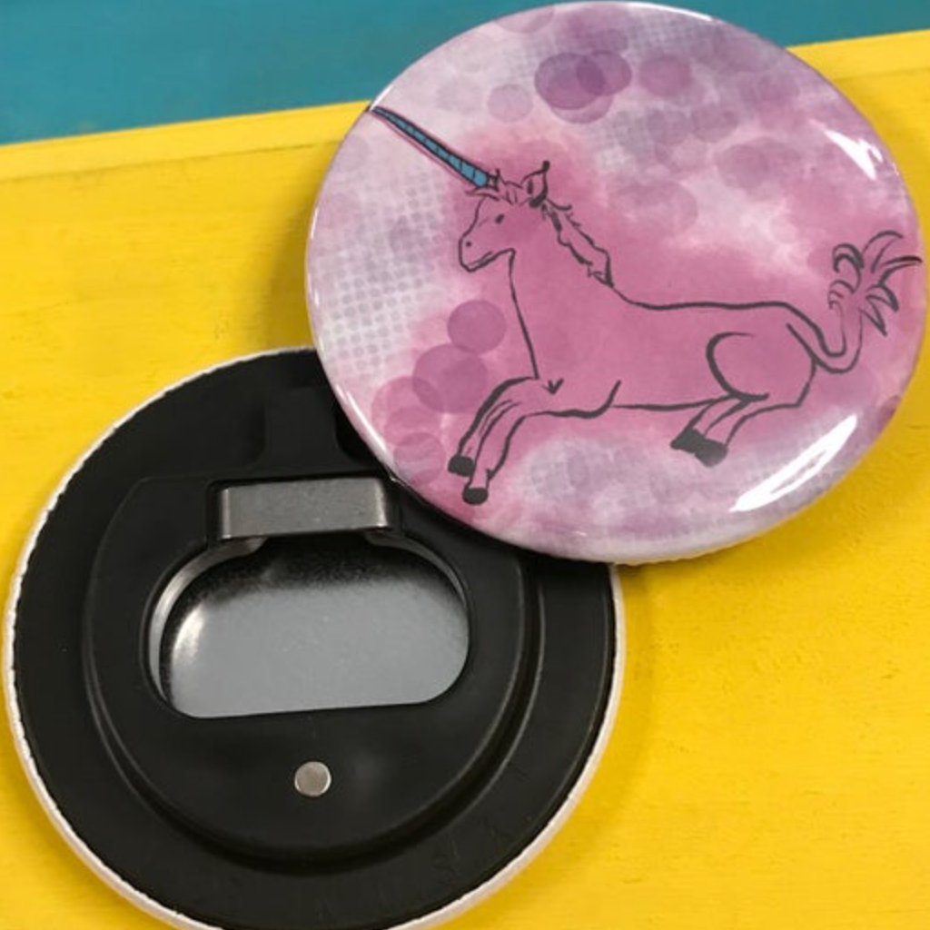 Pink unicorn bottle opener on a yellow surface