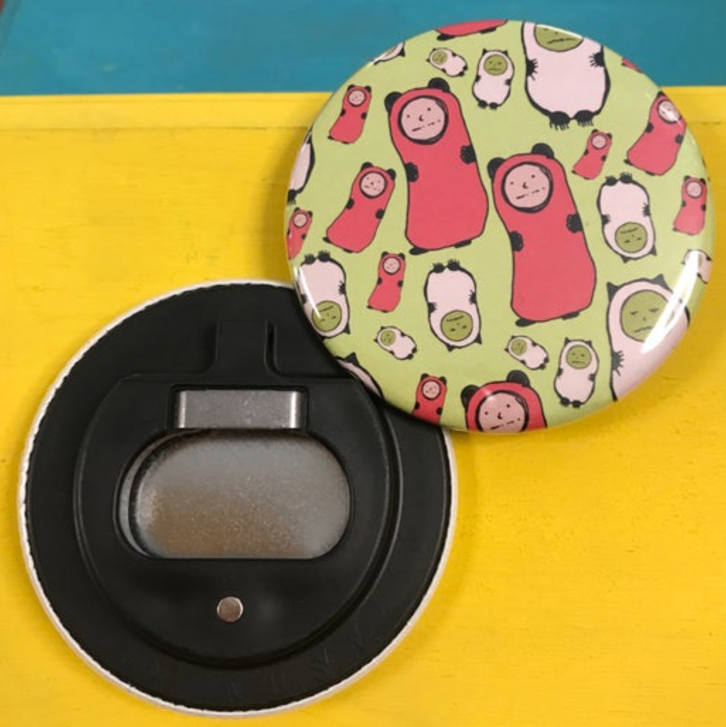 Bottle opener with a colorful character design on a yellow surface