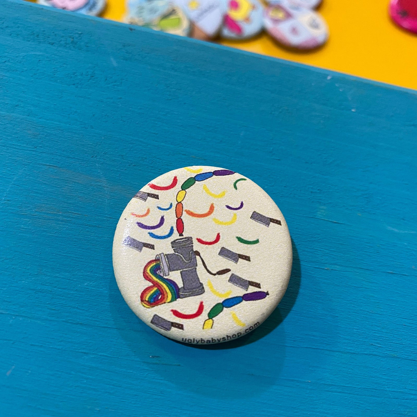 Button badge with colorful design on a blue surface