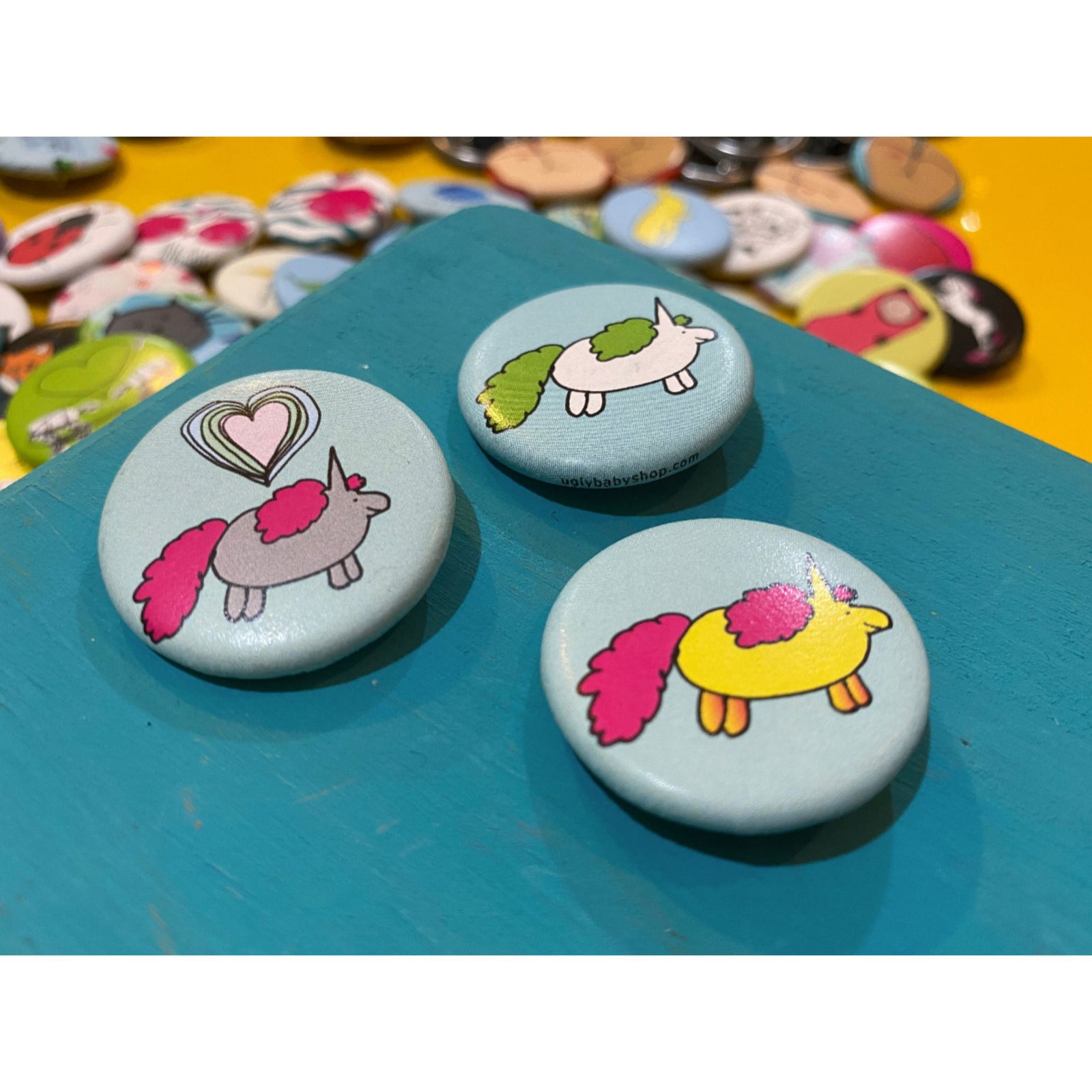 Three colorful buttons with cartoon designs on a blue surface.