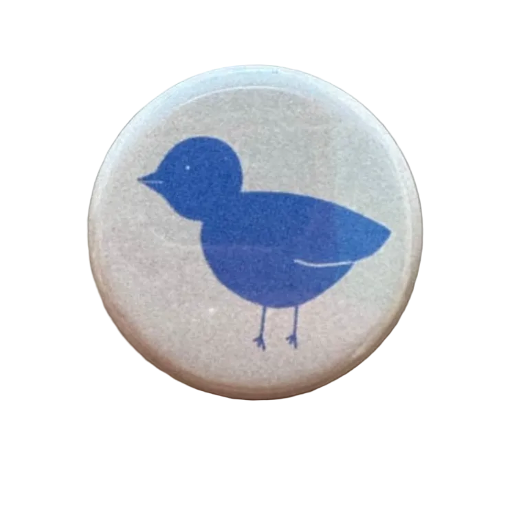Round button with a blue bird design 