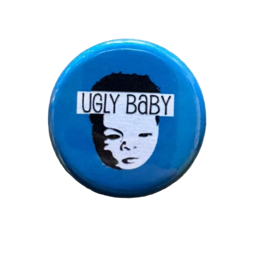 Blue button with 'UGLY BABY' text and a face graphic 