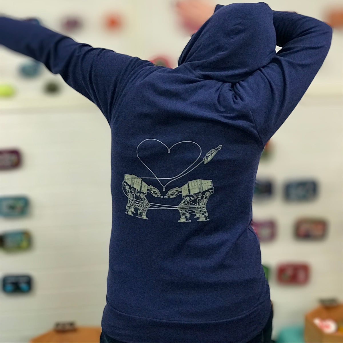 Heathered royal blue triblend unisex hooded sweatshirt. Two AT-AT's are shown falling in love.