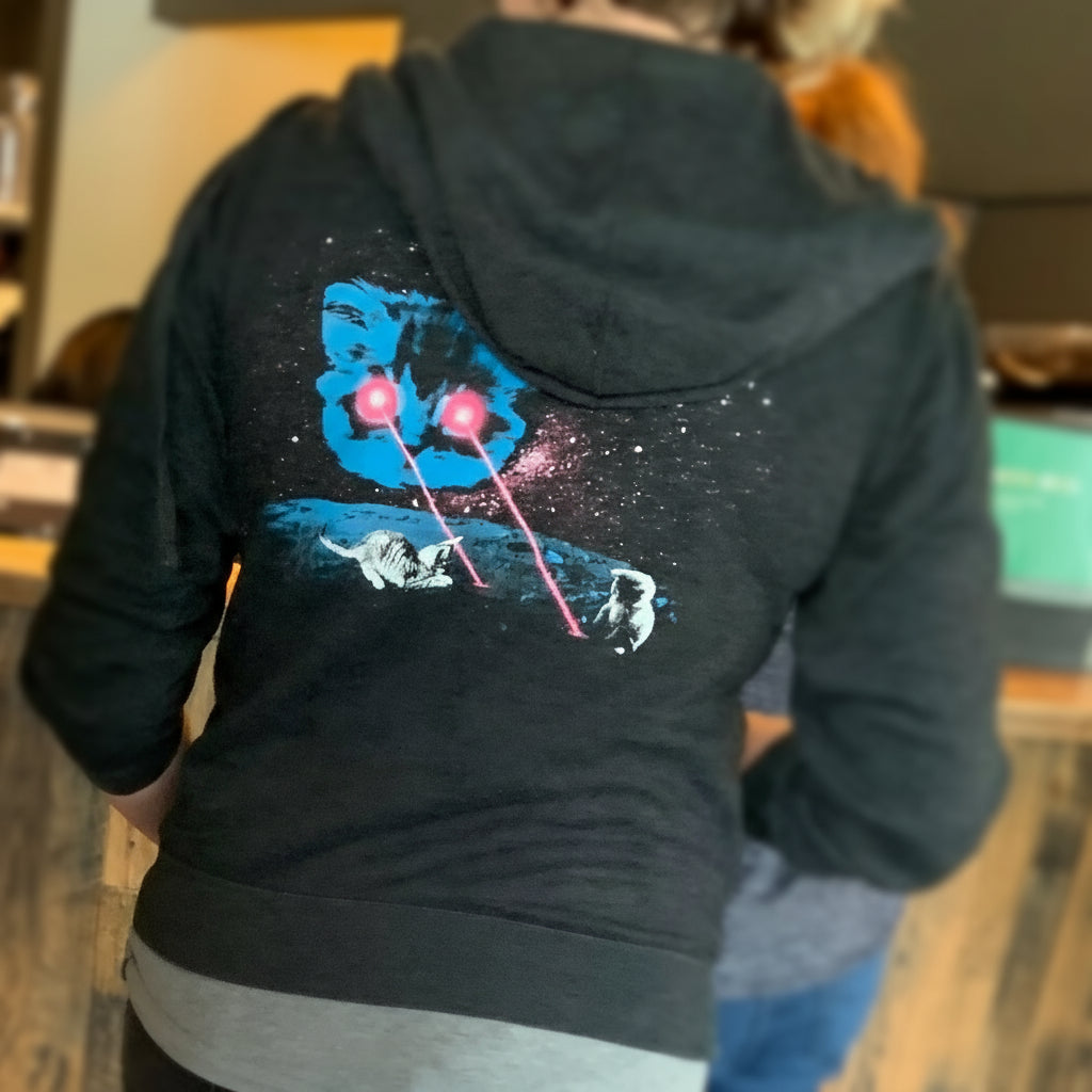 Two people sitting on a bench in a tiled room with a wooden floor.