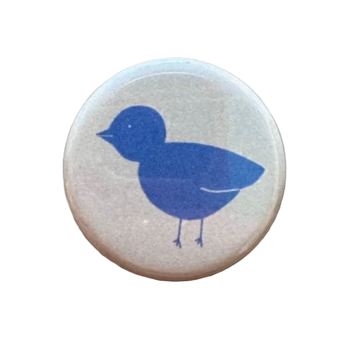 Round magnet with a blue bird design on a white background.