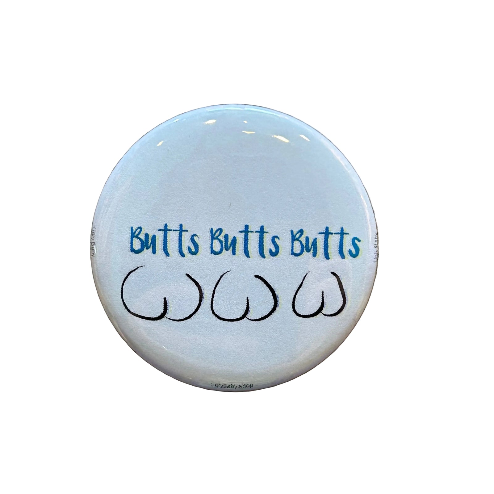 Round white magnet with three line drawings of butts and text that says "Butts Butts Butts"