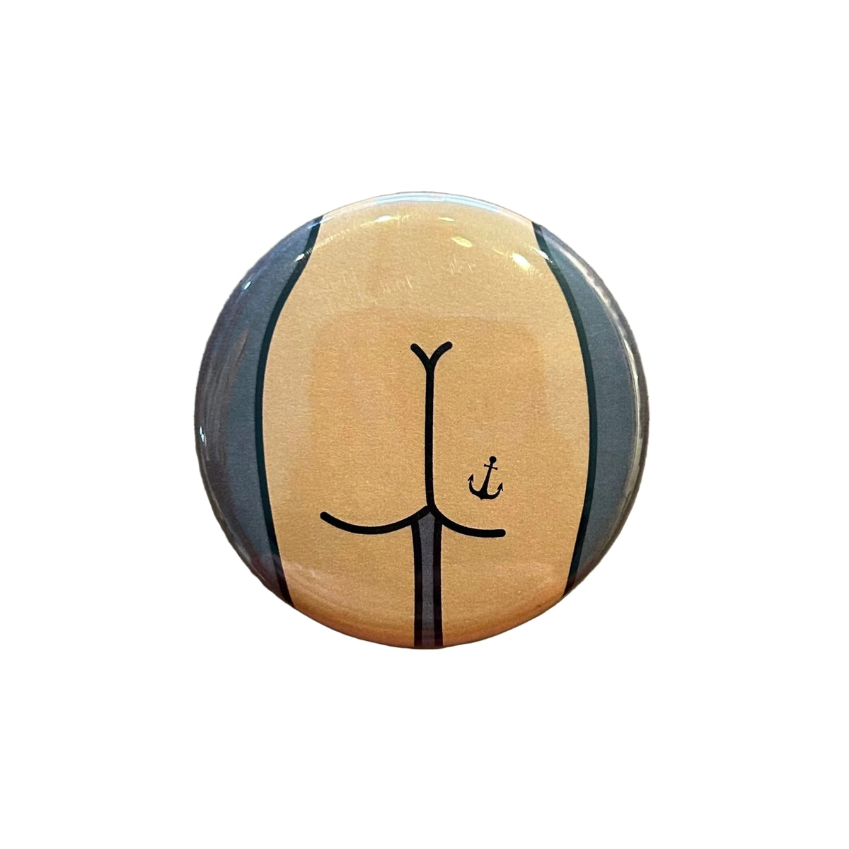 Round magnet with a cartoon butt design against a white background. 