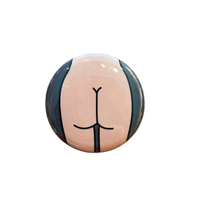 Round magnet with a stylized depiction of a butt against a white background. 