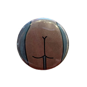 Round magnet with a cartoon illustration of a butt against a white background