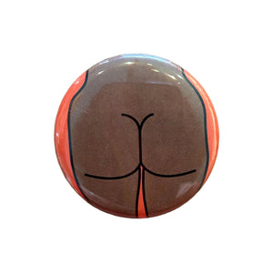 Round magnet with a cartoon illustration of a butt against a white background