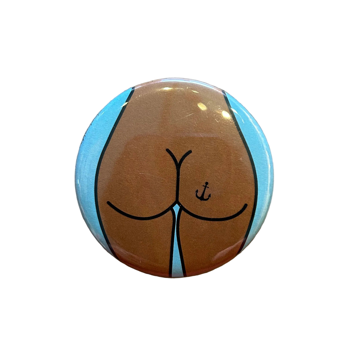 Round magnet with a cartoon illustration of a butt against a white background