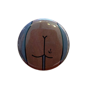 Round magnet with a cartoon illustration of a butt against a white background. 