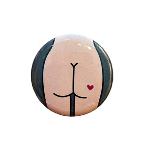 Round magnet with a cartoon illustration of a butt against a white background. 