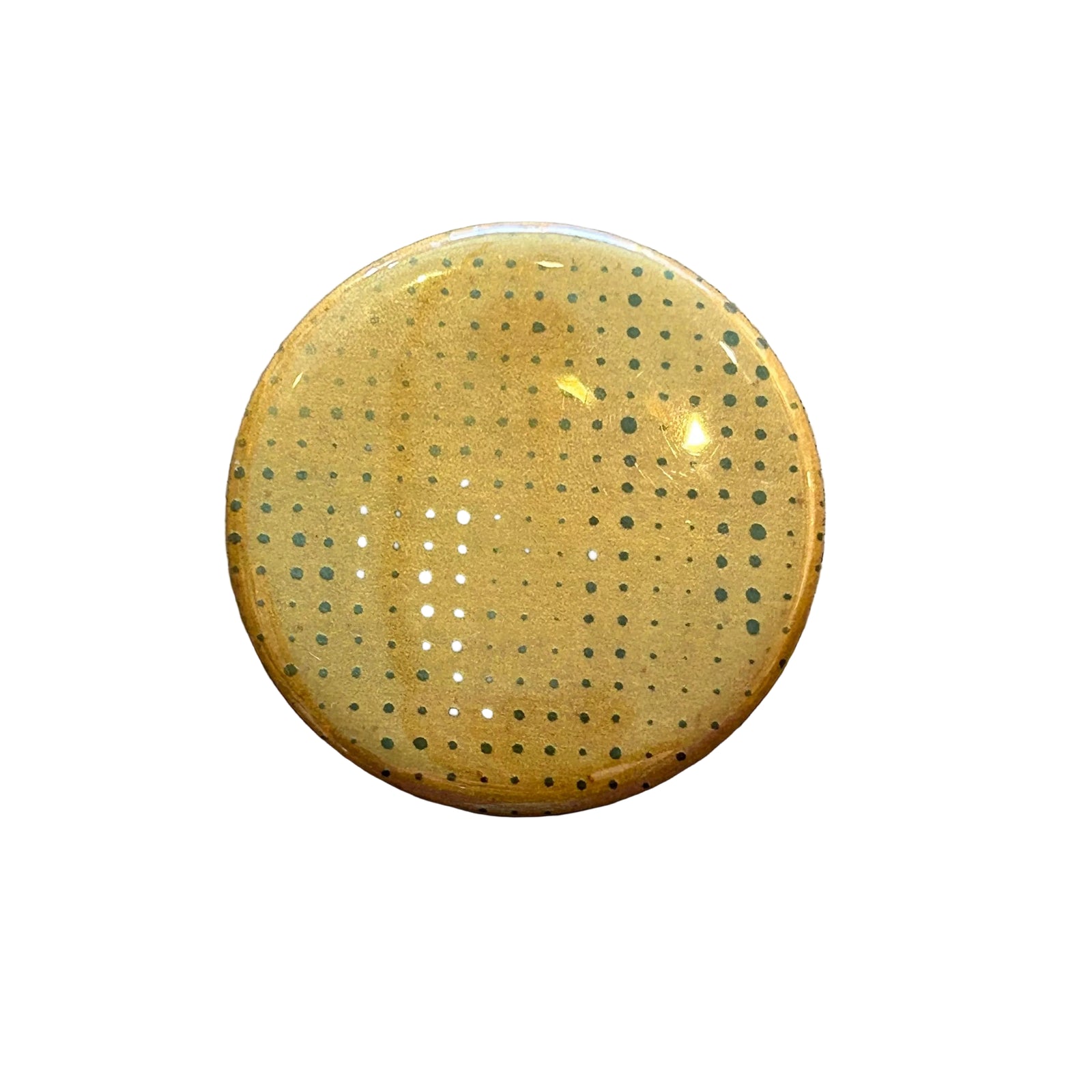 Round orange magnet with a dot pattern against a white background. 