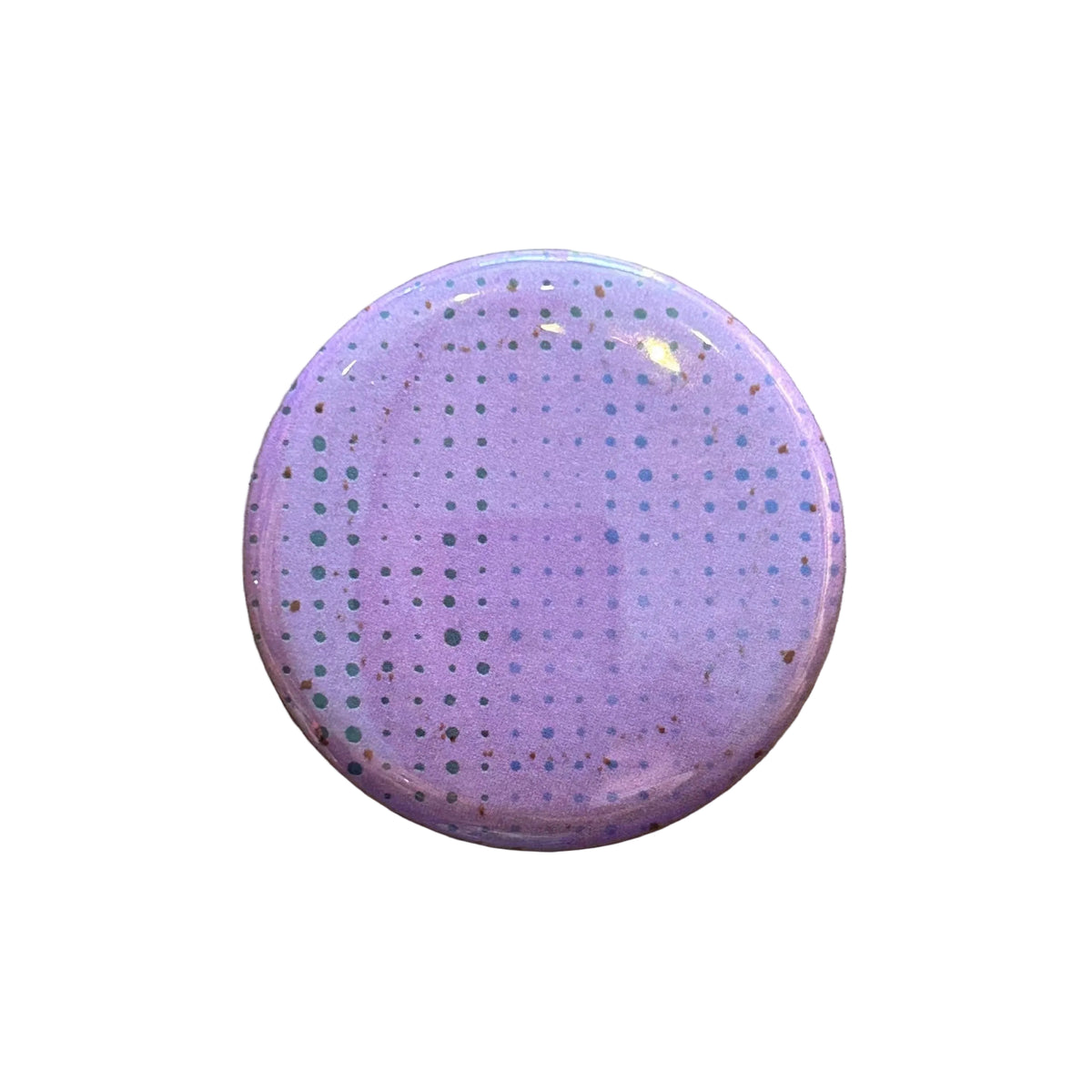 Round pink magnet with a dot pattern against a white background