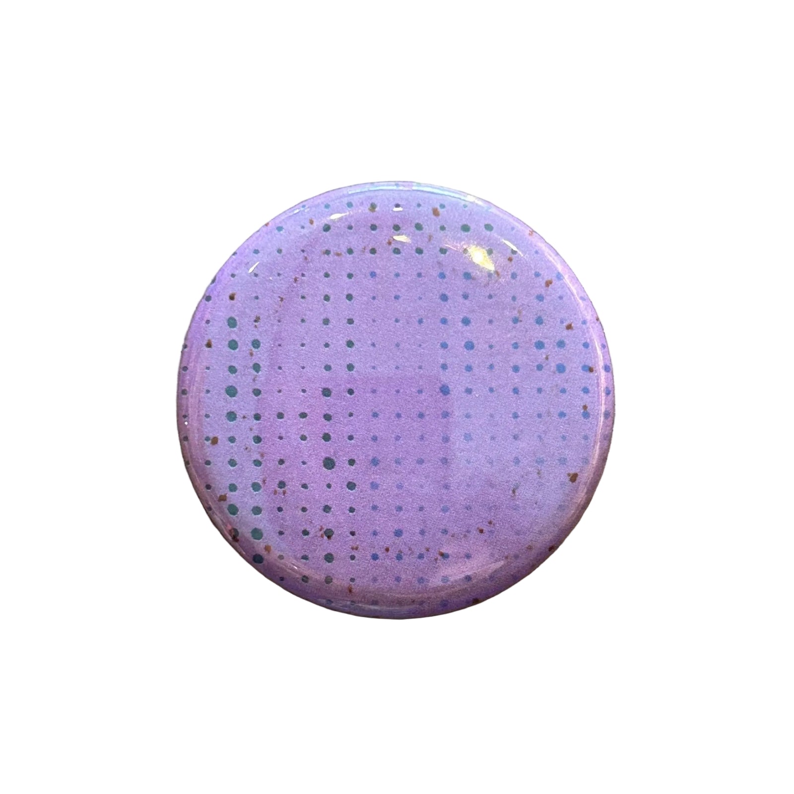 Round pink magnet with a dot pattern against a white background