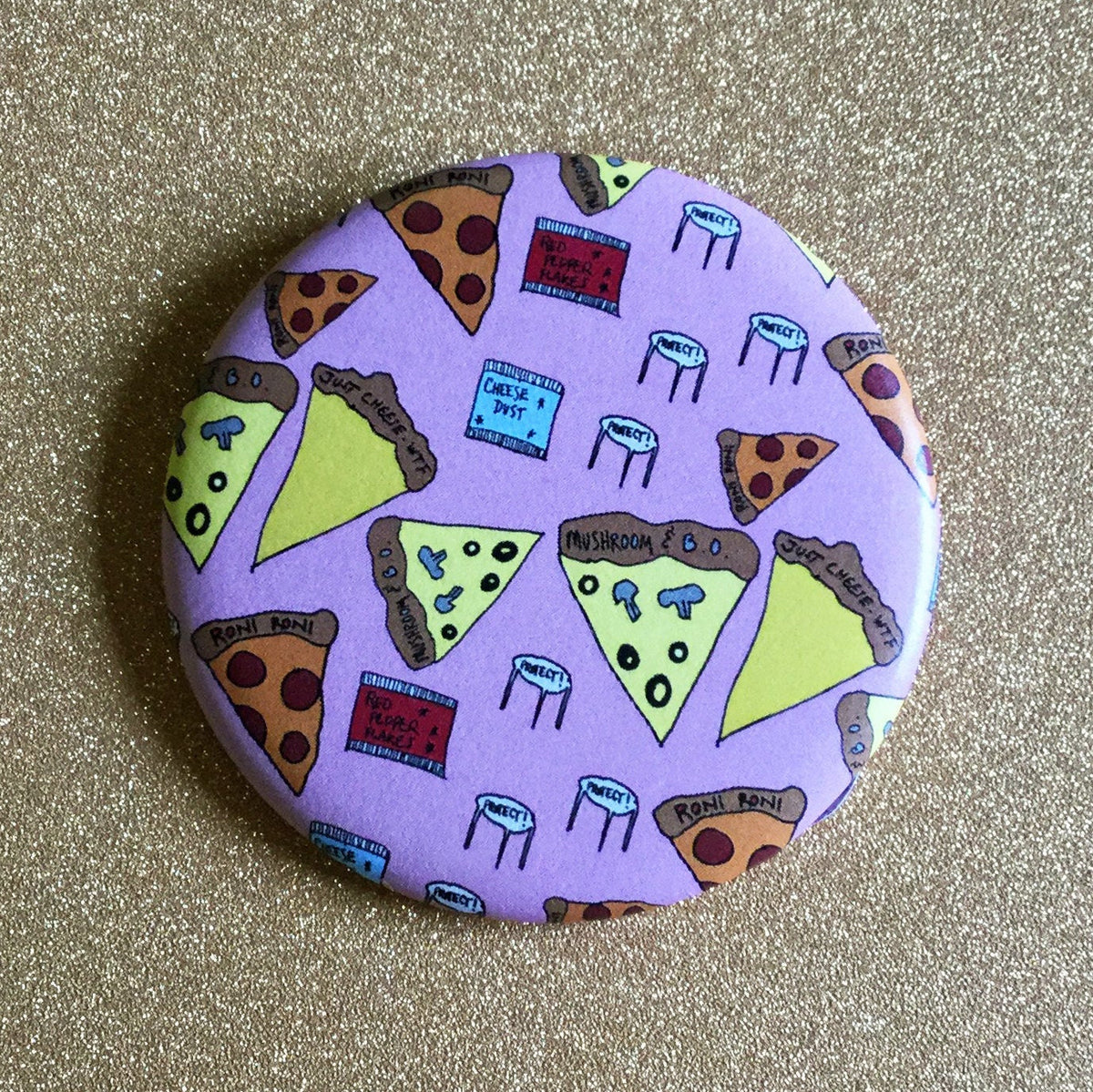 Round pink magnet with illustrations of pizza slices, cheese and red pepper packets, and speech bubbles that say "perfect!"