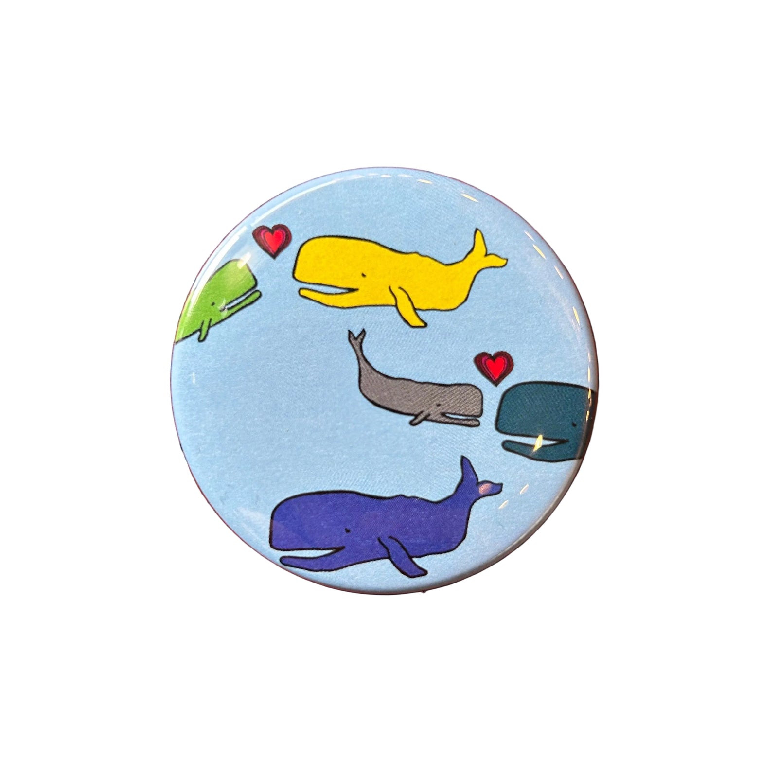 Round blue magnet with various whale illustrations on it 