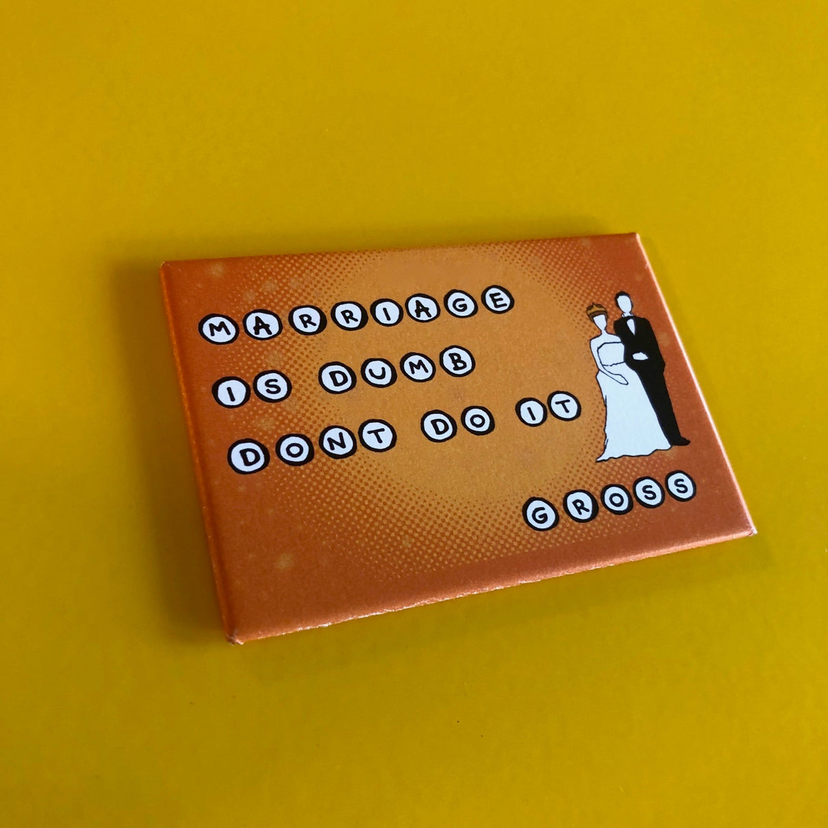 Orange rectangular magnet with an illustration of a bride and groom and text that says "MARRIAGE IS DUMB DON'T DO IT GROSS"