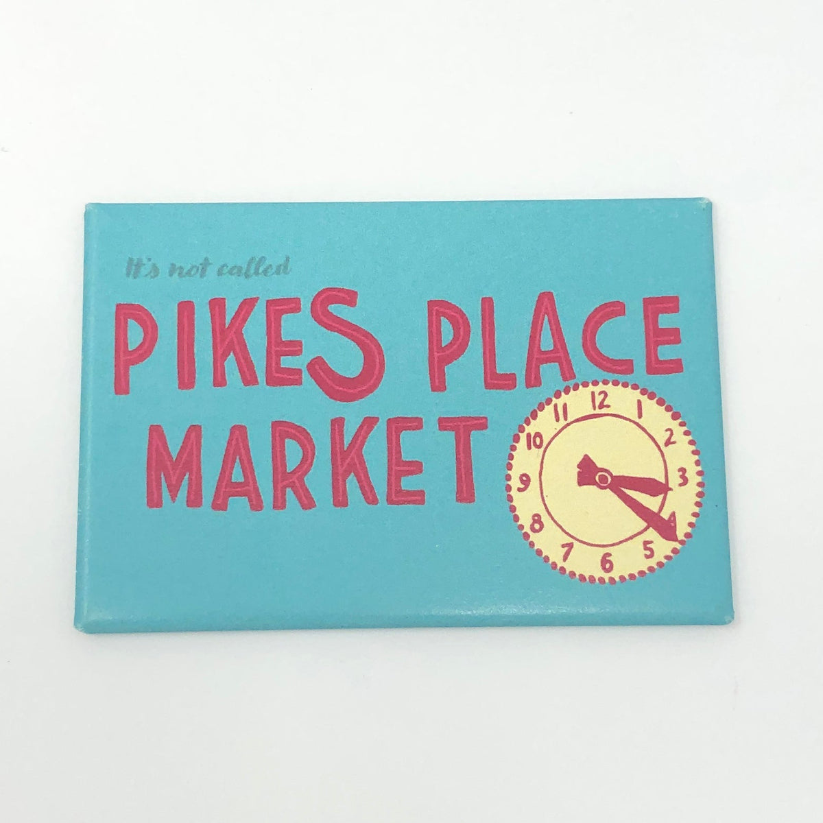 Blue rectangular magnet with an illustration of a clock and red text that says "it's not called Pikes Place Market"