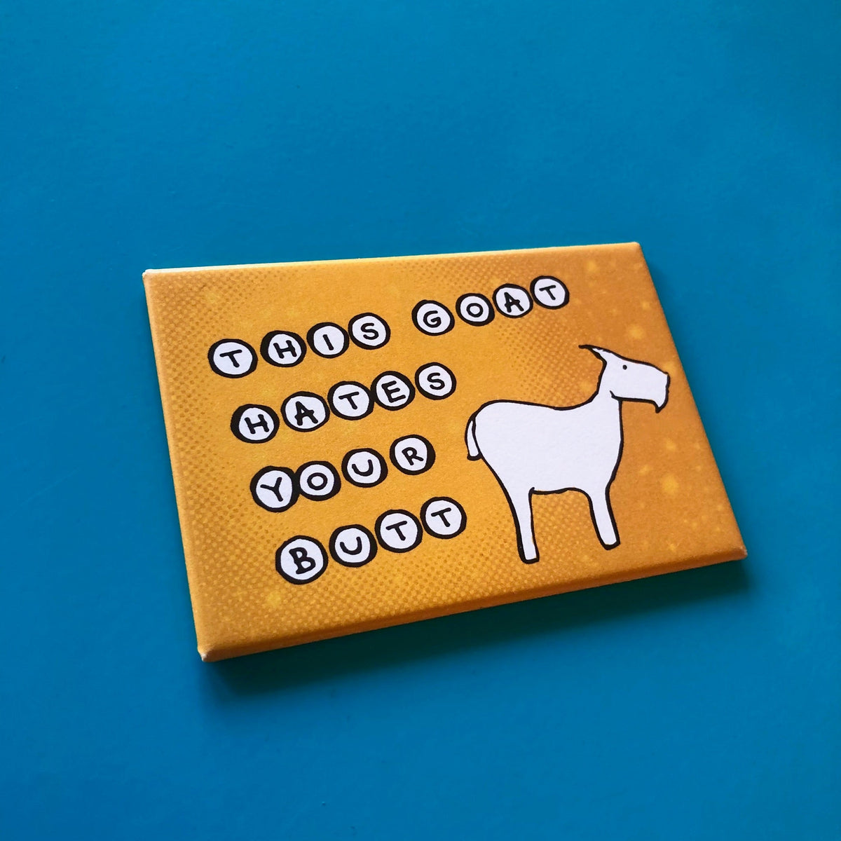 Orange rectangular magnet with an illustration of a goat and text that says "THIS GOAT HATES YOUR BUTT"
