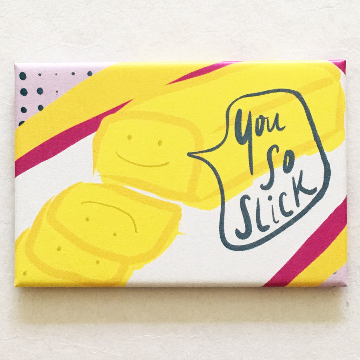 Rectangular magnet with an illustration of a stick of butter cut up into squares with a speech bubble that says "you so slick"